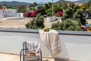 a chair on a balcony with a table with a towel at Via Tirso Rooms & Studio in Tortolì