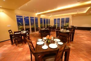a dining room with tables and chairs and windows at Silver Pride Boutique Hotel in Jaipur