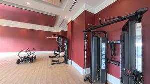 a gym with cardio equipment in a room with red walls at C5103 Outstanding Studio in the Heart of Downtown in Miami