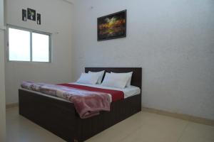 a bedroom with a large bed with red and white pillows at Hotel dream sagar in Sāgar