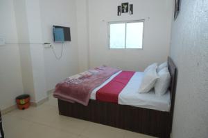 a bedroom with a bed with a tv on the wall at Hotel dream sagar in Sāgar