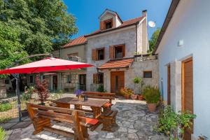 a patio with a wooden table and an umbrella at Luxury Resort Dobri Dida in Imotski