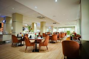 a dining room with tables and chairs in a restaurant at Alisa Hotel North Ridge in Accra