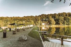 a group of tables and chairs next to a lake at Forest Camping Resort Blaguš in Sveti Jurij ob Ščavnici