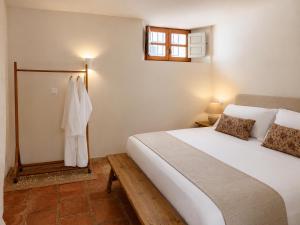 a bedroom with a large white bed and a window at Finca Soleá in Zahara de la Sierra +83 photos