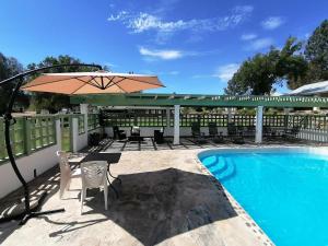 a patio with a table and an umbrella next to a pool at Rancho Meling in Camalú