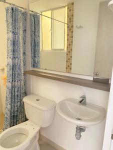 a bathroom with a toilet and a sink and a mirror at Valparaiso in Valledupar