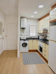 a kitchen with white cabinets and a dishwasher at Apartamento Altafulla in Altafulla