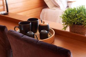 a tray with coffee cups and a potted plant at Encantos de Altitude Cabanas e Studio Container in São Joaquim
