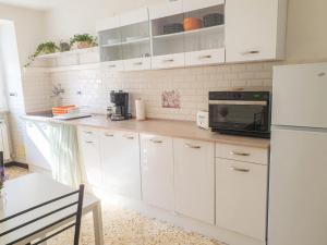 a kitchen with white cabinets and a black microwave at La Casetta in Genoa +4 photos