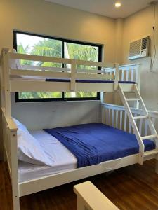 a bedroom with two bunk beds and a window at Casa de Lilong in Mahinog