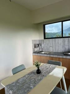a kitchen with a table with chairs and a sink at Casa de Lilong in Mahinog