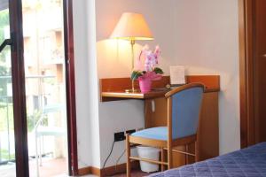a bedroom with a desk with a lamp and a chair at Arcangelo Meublè in Rimini