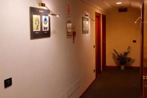 a hallway with a white wall with pictures on it at Arcangelo Meublè in Rimini
