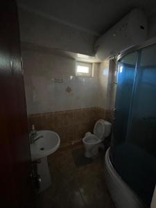 a small bathroom with a toilet and a sink at Келечек in Cholpon-Ata