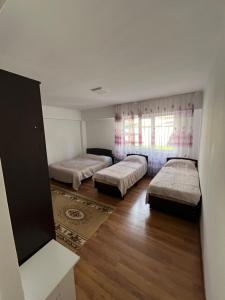 a room with three beds and a window at Келечек in Cholpon-Ata +2 photos