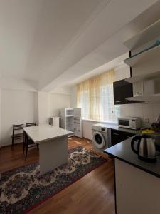 a kitchen with a table and a counter top at Келечек in Cholpon-Ata