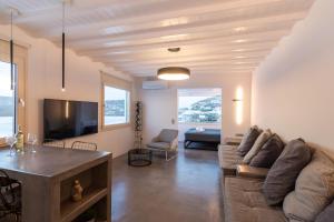 a living room with a couch and a tv at The Rock View Apartment in Mikonos