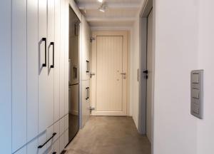 a hallway with white cabinets and a white door at The Rock View Apartment in Mikonos