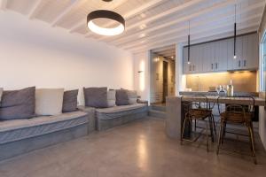 a kitchen and living room with a couch and a table at The Rock View Apartment in Mikonos