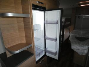 an empty refrigerator with its door open in a room at Szentkút Kemping Vasvár in Vasvár