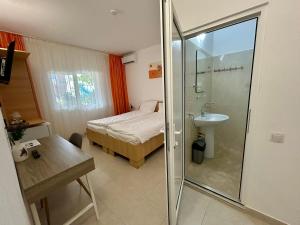 a bedroom with a bed and a shower and a sink at Casa Double M, Vama Veche in Vama Veche