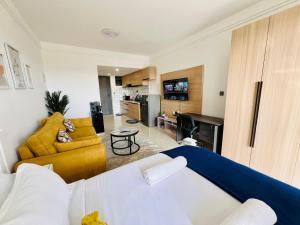 a living room with a bed and a couch at Nyvin Homes at The Loftel in Ruaka +32 photos
