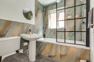 a bathroom with a sink and a toilet and a tub at Contractor Base Parking 4 Beds Fast Wi-Fi in Bolton upon Dearne