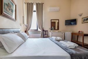 a bedroom with a large white bed with towels on it at Guesthouse Bel Duomo in Florence