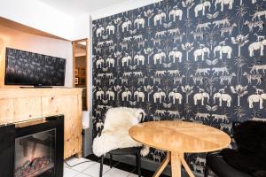 a living room with a table and a wallpaper with animals at Daiches Braes Brunstane Portobello in Edinburgh