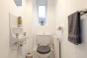 a white bathroom with a toilet and a sink at Contractor Base Parking 4 Beds Fast Wi-Fi in Bolton upon Dearne