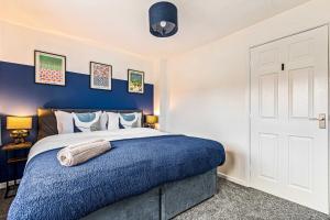 a bedroom with a blue accent wall and a bed at Contractor Base Parking 4 Beds Fast Wi-Fi in Bolton upon Dearne +27 photos