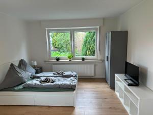 a white bedroom with a bed and a window at Green View - JK Apartments in Datteln
