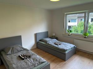 two beds sitting in a room with a window at Green View - JK Apartments in Datteln