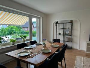 a dining room table with chairs and a large window at Green View - JK Apartments in Datteln