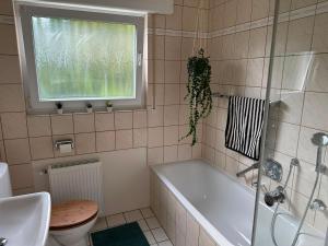 a bathroom with a tub and a toilet and a window at Green View - JK Apartments in Datteln +11 photos