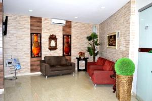 a living room with a red couch and a chair at Larison Economy - by Easy Hotéis in Porto Velho