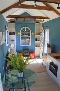 a living room with a glass table and blue walls at Cockloft Romantic Countryside Hideaway in Bishops Cannings