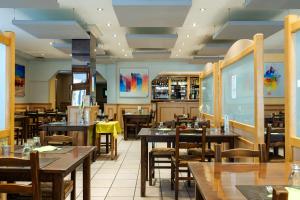 a dining room with wooden tables and chairs at Logis Hôtel Restaurant Bellevue Annecy in Annecy