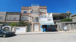 a building with a car parked in front of it at Appartement Ezzdine sfaxi in Kelibia