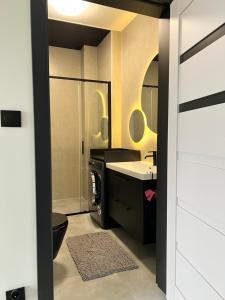a bathroom with a black toilet and a sink at Apartament w Kębłowie in Kębłowo