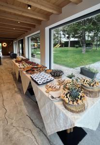 a row of tables with food on them at Hotel alle Rose Family inspired garden and SPA in Cavedago