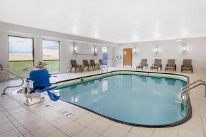 a pool in a hotel room with chairs and tables at Best Western Forsyth-Decatur in Forsyth