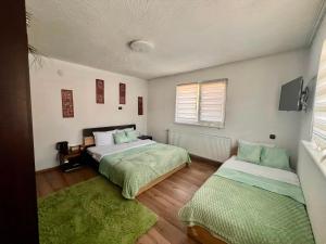 a bedroom with two beds and a window at Къща за гости Шанови in Gʼovren +17 photos