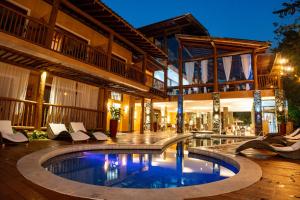 a house with a swimming pool in front of a building at Kalango Hotel Boutique in Ilhabela