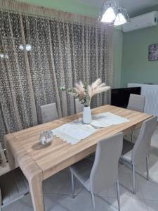 a dining room table with a vase of flowers on it at Seaside Vatera in Vatera