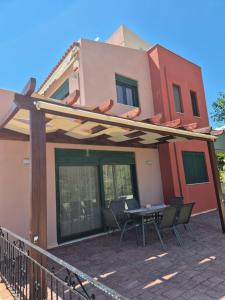 a patio with a table and chairs in front of a house at Seaside Vatera in Vatera