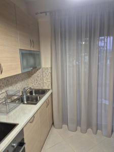 a kitchen with a sink and a shower curtain at Seaside Vatera in Vatera +40 photos
