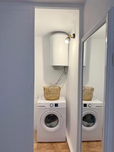 a laundry room with a washing machine and a mirror at Nicola`s Apartment in Sozopol