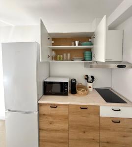 a kitchen with a white refrigerator and a microwave at Nicola`s Apartment in Sozopol